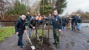Aanplant laatste boom met wethouder van Rijn. Rechts is aanplant moerasbos zichtbaar